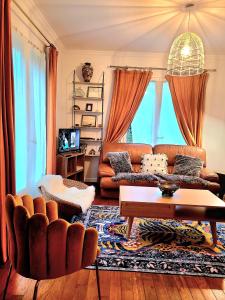 a living room with a couch and a table at PEACE & PINK Maison zen & Cocon stylé a 5 mn des vagues de Wimereux in Maninghen-Henne