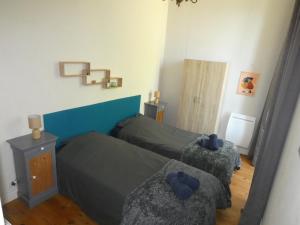 een kleine slaapkamer met 2 bedden en een tafel bij Gîte de la Ferme Feugère in Barbeville