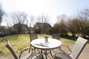 a white table and chairs in a field at Stephan in Petersdorf auf Fehmarn