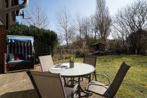 a table and chairs in a yard with a table and a chair at Stephan in Petersdorf auf Fehmarn