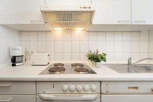 a white kitchen with a stove and a sink at Stephan in Petersdorf auf Fehmarn