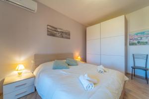 a bedroom with a white bed with towels on it at Tilly by DomusAway in Olbia +30 photos