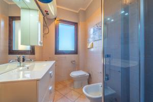 a bathroom with a toilet and a sink and a shower at Tilly by DomusAway in Olbia