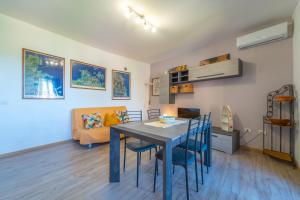 a dining room and living room with a table and chairs at Tilly by DomusAway in Olbia