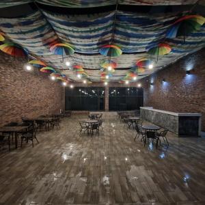 a large room with tables and umbrellas on the ceiling at Arena Hotel Tartar in Terter