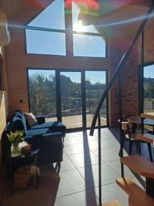 a living room with a couch and a large window at Domek w Sośninie, stodoła Dzierżenin in Dzierzenin