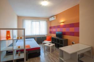 Kleines Zimmer mit einem Bett und einem Schreibtisch. in der Unterkunft Marina Apartment in Sofia