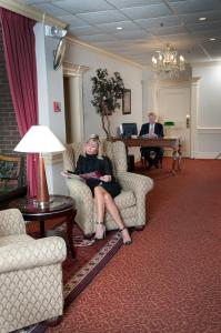 Amsterdam Hotel في ستامفورد: امرأة تجلس على كرسي في غرفة انتظار