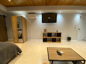 a room with a bed and a tv on a wall at Mindarie beachside studio in Mindarie