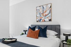 a bedroom with a bed with blue and white pillows at Urban Living at Its Best in Carnegie