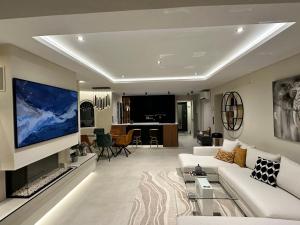a living room with a white couch and a large tv at Villa Vega Luxury in Cautivador