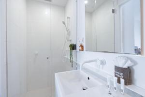 a white bathroom with a sink and a shower at Urban Living at Its Best in Carnegie +17 photos