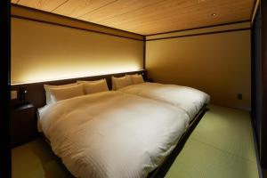 a large white bed in a small room at Enso Machiya in Kyoto
