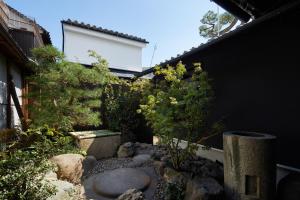 a garden with a stone bowl in the side of a building at Enso Machiya in Kyoto +37 photos