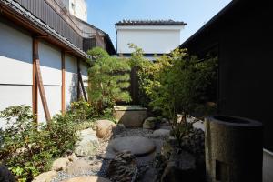 a garden with rocks and plants in front of a building at Enso Machiya in Kyoto