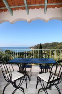 einen blauen Tisch und Stühle auf einem Balkon mit Meerblick in der Unterkunft Residenza l 'Alivetu in Cargèse