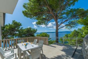 un tavolo e sedie su un patio con vista sull'acqua di A Minute to the Sea Brela a Brela