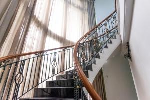 a staircase with a wrought iron railing and a window at INNCA Telaga Bodas, Semarang in Jatingaleh