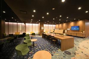 a waiting room with tables and chairs and a flat screen tv at Shinjuku Prince Hotel in Tokyo