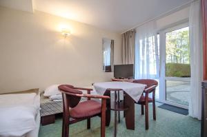 a hotel room with a table and chairs and a window at Willa Koron a Mielno in Mielno