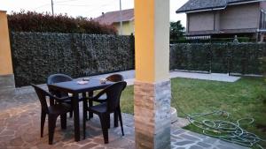 a table and chairs on a patio with a garden at Appartamento Malpensa Rho in Samarate