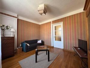 ein Wohnzimmer mit Sofa und Tisch in der Unterkunft Le nid d'Hirondelle in Vanault-les-Dames + 1 Foto