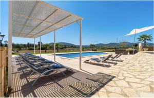 a group of lounge chairs next to a swimming pool at Villa Lorenzo Manacor by PriorityVillas in Manacor