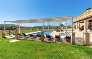a swimming pool with chairs and a pavilion at Villa Lorenzo Manacor by PriorityVillas in Manacor