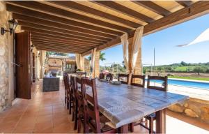 an outdoor dining area with a table and chairs and a pool at Villa Lorenzo Manacor by PriorityVillas in Manacor