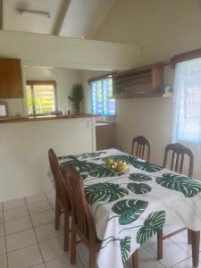 a kitchen with a table with a tablecloth with fruit on it at Sharnytas Guesthouse AIR CONDITIONED in Avarua