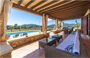 an outdoor patio with tables and chairs and a pool at Villa Lorenzo Manacor by PriorityVillas in Manacor +42 photos