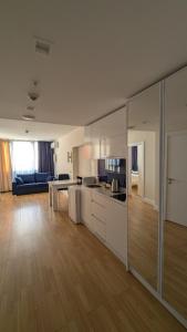 a kitchen with white cabinets and a living room at Orbi City, block C in Batumi