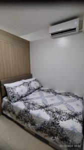a bedroom with a bed with a comforter and pillows at Shore 2 Tower 1 JMB Staycation in Manila +8 photos