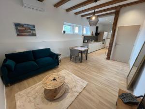 a living room with a blue couch and a table at Charme et confort au cœur des remparts - duplex in Dambach-la-Ville