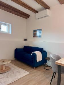 a blue couch in a living room with a table at Charme et confort au cœur des remparts - duplex in Dambach-la-Ville