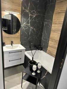 a bathroom with a sink and a tub and a table at Lux apartament in Gniezno