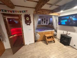a room with a tub with a tv and a stool at Sioło Bobolin II in Bobolin