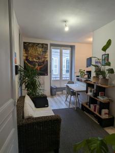 a living room with a couch and a table and a desk at Les jardins de Beauverger in Le Mans