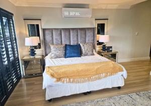 a bedroom with a large bed with blue pillows at Bona Bali 14, Zimbali Estate by Euphoric Leisure in Ballito