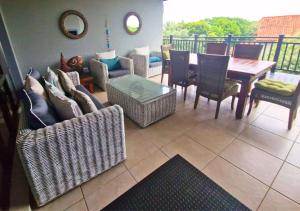 a living room with chairs and a table and a balcony at Bona Bali 14, Zimbali Estate by Euphoric Leisure in Ballito