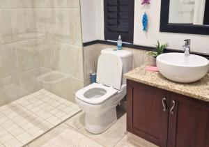 a bathroom with a white toilet and a sink at Bona Bali 14, Zimbali Estate by Euphoric Leisure in Ballito +15 photos
