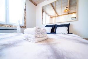 a bedroom with a bed with towels on it at La Petite Parenthèse Jardin, Parking & Proche Gare in Trappes