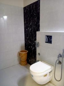 a bathroom with a white toilet and a black wall at Prince Hotel And Restaurant in Jaipur