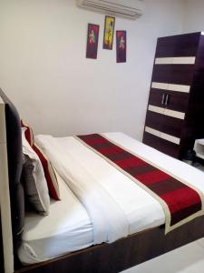 a bedroom with a bed with a striped blanket at Prince Hotel And Restaurant in Jaipur