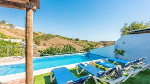 a pool with chaise lounge chairs and a swimming pool at Casa La Estrella Azul Vélez-Málaga by Ruralidays in Vélez-Málaga