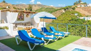 a group of blue chairs and an umbrella on a patio at Casa La Estrella Azul Vélez-Málaga by Ruralidays in Vélez-Málaga