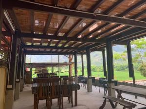 a pavilion with tables and chairs and tables and windows at Green Homestay Mai Chau in Mai Châu