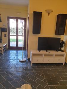 un soggiorno con TV a schermo piatto su un tavolo di Casa Bonifati a Cittadella del Capo