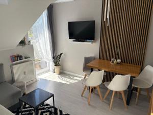 a living room with a table and chairs and a television at Jagodowy Agat in Dziwnówek