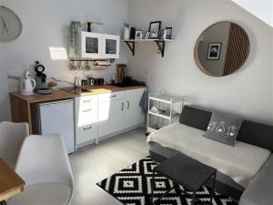 a living room with a couch and a kitchen at Jagodowy Agat in Dziwnówek +4 photos